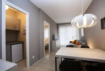 a living room with a dining room table and a kitchen at Bcn Sagrada Familia Apartments in Barcelona