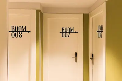 two white doors with the words roomox and the words runidas at Room018BCN in Barcelona