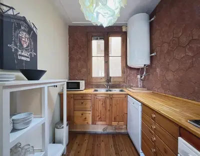 a kitchen with wooden cabinets and a sink at The Collection Barcelona - Paseo St Joan classic 4BD for 10 guests in Barcelona