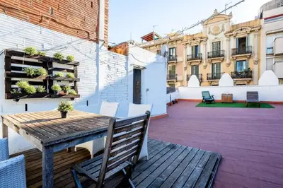 a wooden table and chairs on a rooftop patio at The Collection Barcelona - Private terrace Attico 3BD in Gran de Gracia in Barcelona