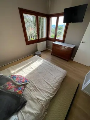 a bedroom with a large bed in a room with windows at Casa familiar en la playa con piscina in Teià