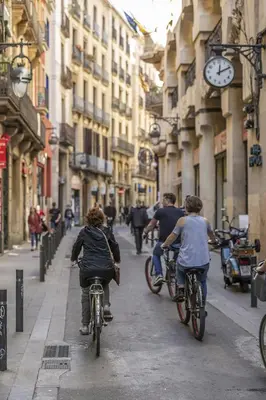 a group of people riding bikes down a city street at Hostal Sol y K in Barcelona