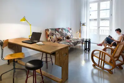 a woman sitting on a couch in a living room with a laptop at Best House Best Place in Barcelona