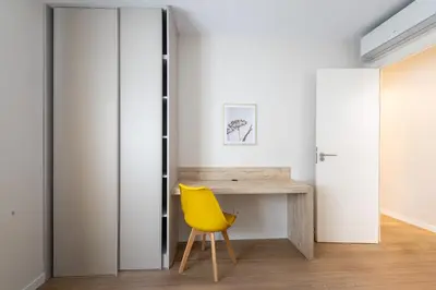 a yellow chair in a room with a desk at MadreMia - Chic Hub Barcelona in Hospitalet de Llobregat