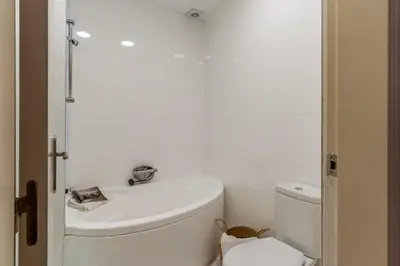 a white bathroom with a toilet and a sink at Canela Homes BARCELONA JARDINETS in Barcelona