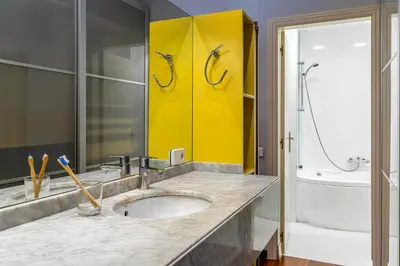 a bathroom with a sink and a yellow wall at Canela Homes BARCELONA JARDINETS in Barcelona