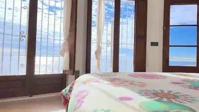 a bedroom with windows and a bed with a floral blanket at Tot Gaviota in Sitges