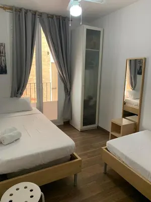 a bedroom with two beds and a balcony at Apartament modern al carrer Blai, Poble Sec in Barcelona