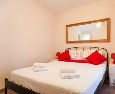a bedroom with a bed with red pillows and a mirror at Apartament modern al carrer Blai, Poble Sec in Barcelona