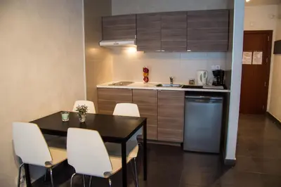 a kitchen with a dining room table and white chairs at Villa Sagrada in Barcelona