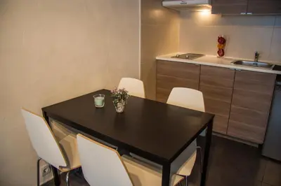 a kitchen with a black table and white chairs at Villa Sagrada in Barcelona