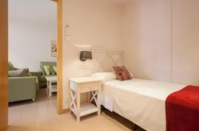 a small bedroom with a bed and a couch at Rosselló Apartment in Barcelona