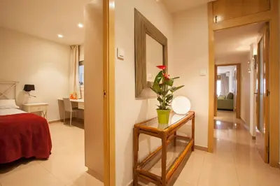 a bedroom with a bed and a table with a flower on it at Rosselló Apartment in Barcelona