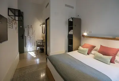 a bedroom with a large white bed with orange pillows at Casa Mathilda in Barcelona