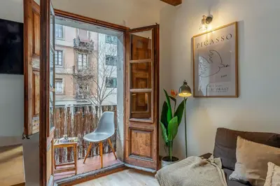 a room with a window and a chair next to a door at Canela Homes BARCELONA SANT ANTONI in Barcelona