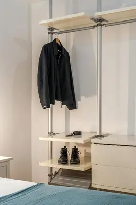 a bedroom with a shelf with a black jacket and shoes at Canela Homes BARCELONA SANT ANTONI in Barcelona