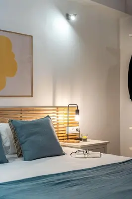 a bedroom with a bed and a table with a lamp at Canela Homes BARCELONA SANT ANTONI in Barcelona