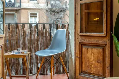 a blue chair sitting on a balcony next to a door at Canela Homes BARCELONA SANT ANTONI in Barcelona
