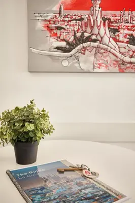 a table with a potted plant and a painting at BBarcelona Sagrada Familia Terrace Flat in Barcelona