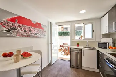 a kitchen with a sink and a table with a bowl of fruit at BBarcelona Sagrada Familia Terrace Flat in Barcelona