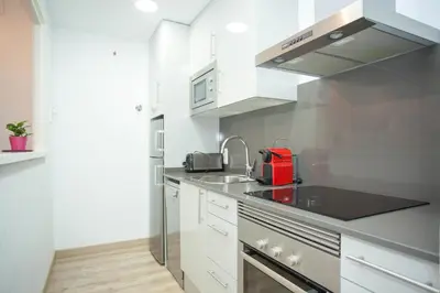 a kitchen with white cabinets and a red appliance at Sitges Center & Beach with Sea View in Sitges
