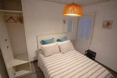 a bedroom with a bed with striped sheets and a chandelier at Flat Top Manager in Barcelona