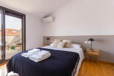 a bedroom with a large bed with towels on it at Elegante dúplex en Terrassa, Barcelona in Terrassa