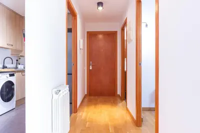a hallway leading to a kitchen with a wooden door at Elegante dúplex en Terrassa, Barcelona in Terrassa