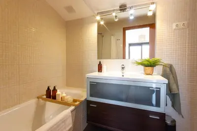 a bathroom with a sink and a tub and a mirror at Elegante dúplex en Terrassa, Barcelona in Terrassa