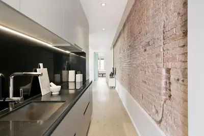 a kitchen with a sink and a brick wall at BCN Town Apartments Portaferrissa in Barcelona