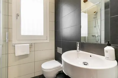 a bathroom with a sink and a toilet and a mirror at BCN Town Apartments Portaferrissa in Barcelona