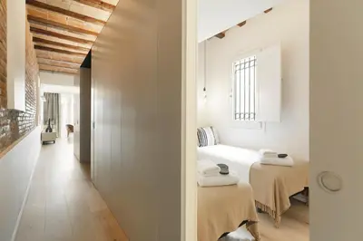 two beds in a room with white walls at BCN Town Apartments Portaferrissa in Barcelona