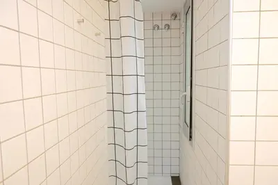 a bathroom with a shower with white tile walls at Homenfun Barcelona Paseo de Gracia Diagonal in Barcelona