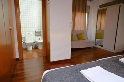 a room with two beds and a bathroom with a toilet at Homenfun Barcelona Paseo de Gracia Diagonal in Barcelona