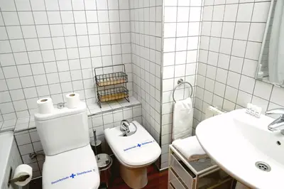 a white bathroom with a toilet and a sink at Homenfun Barcelona Paseo de Gracia Diagonal in Barcelona