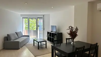 a living room with a couch and a table with a dining room at M1 Céntrico y con balcón in Terrassa