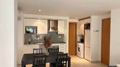 a kitchen with a table and chairs and a kitchen with a refrigerator at M1 Céntrico y con balcón in Terrassa