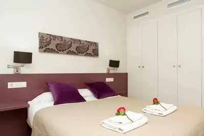 a bedroom with two beds with towels and flowers on them at Port V Apart centrico con estilo 21 in Barcelona