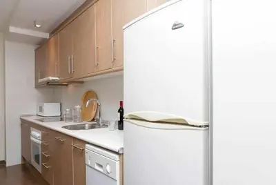 a kitchen with a white refrigerator and a sink at Port V Apart centrico con estilo 21 in Barcelona