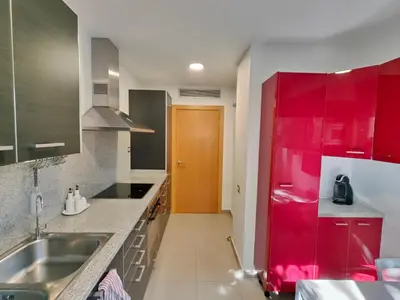 a kitchen with red cabinets and a red door at Family apartment Forum in Sant Adria de Besos
