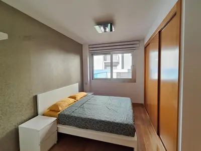 a small bedroom with a bed and a window at Family apartment Forum in Sant Adria de Besos