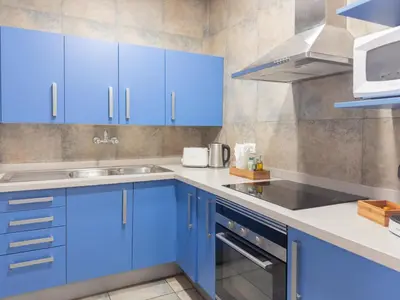 a blue kitchen with a sink and a microwave at Stay U-nique Apartments Nació in Barcelona