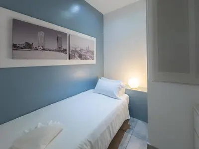 a bedroom with a white bed with a blue wall at Stay U-nique Apartments Nació in Barcelona