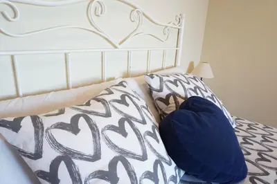 a bed with a heart pillow on top of it at Habitación Atalaya in Olivella