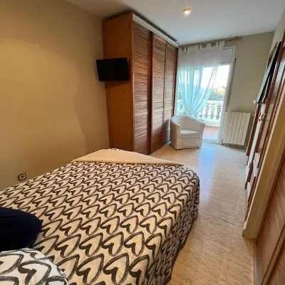 a bedroom with a bed with a blue and white bedspread at Habitación Atalaya in Olivella