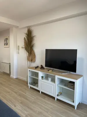 a living room with a television on a white cabinet at Acogedor apartamento Vallparadís con parking in Terrassa