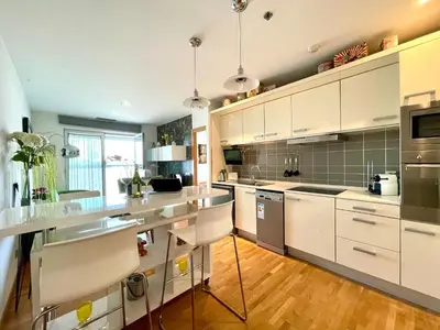 a kitchen with white cabinets and stainless steel appliances at Fira Gran Via - Barcelona4Seasons in Hospitalet de Llobregat