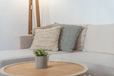 a couch with two pillows and a table at Feel Welcome Barcelona 10 in Cornellà de Llobregat