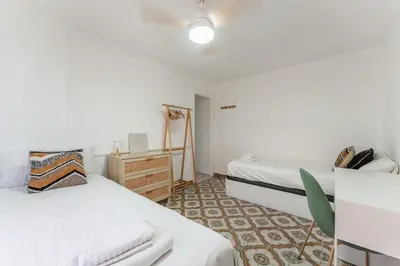 a bedroom with two beds and a dresser in it at Feel Welcome Barcelona 10 in Cornellà de Llobregat