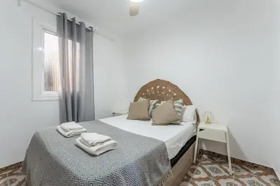 a white bedroom with a bed and a window at Feel Welcome Barcelona 10 in Cornellà de Llobregat